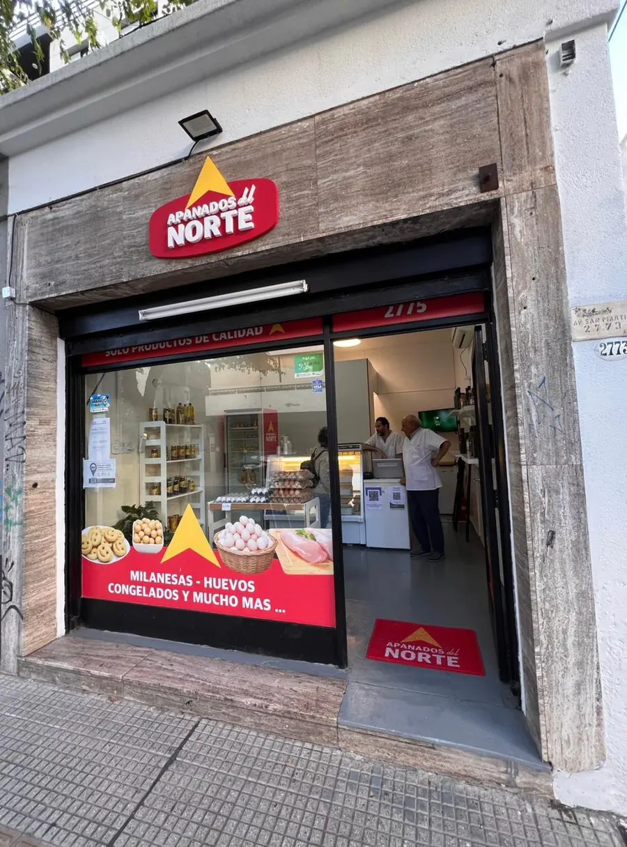 Fachada terminada de Apanados del Norte con el cartel iluminado, la vidriera aplicada y el local abierto