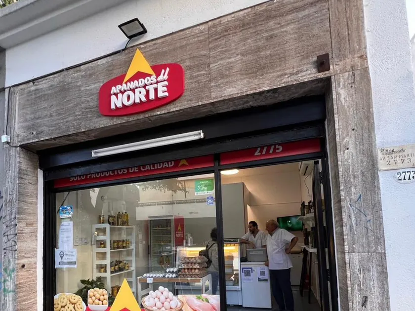 Fachada terminada de Apanados del Norte con el cartel iluminado y el local abierto