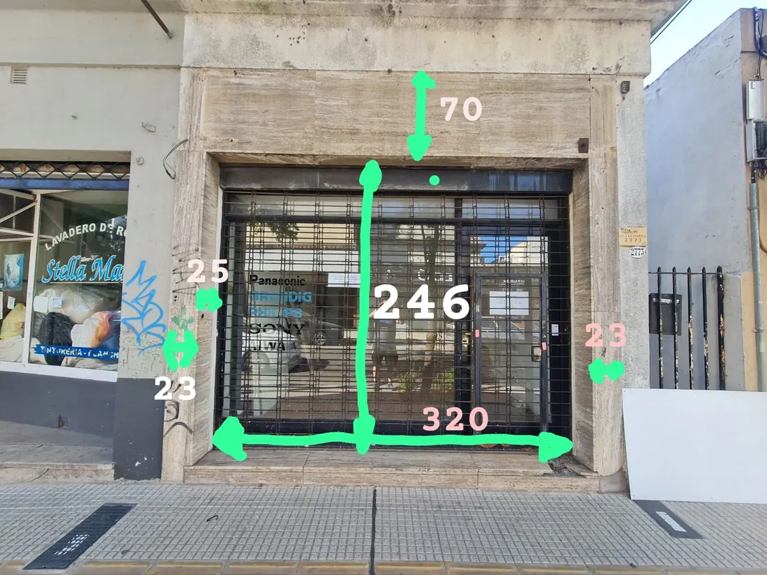 Frente del local todavía vacío con las medidas de la fachada anotadas encima